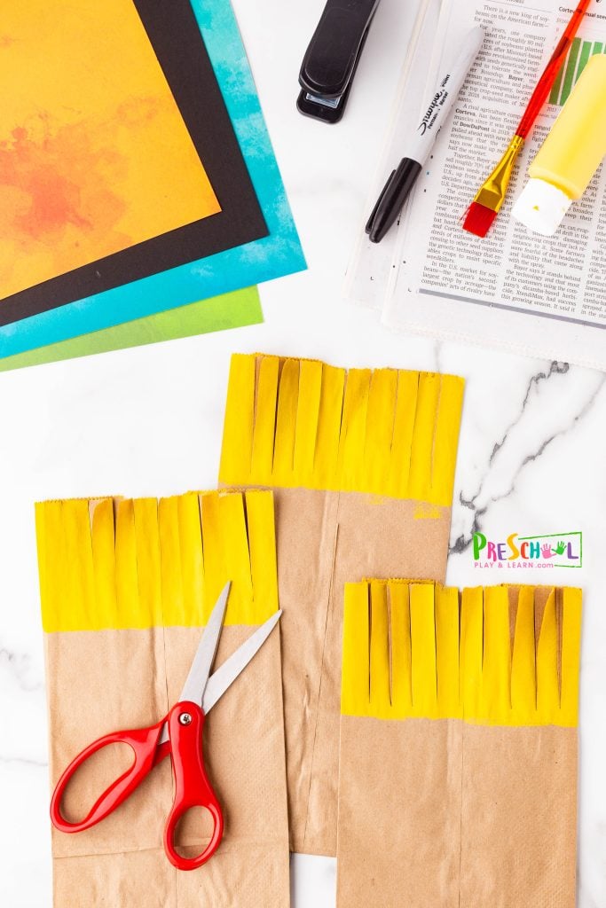 After it dries, grab some scissors and make cuts to the yellow part of the bag to create fun, messy hair! It’s an easy and creative way to transform your project!