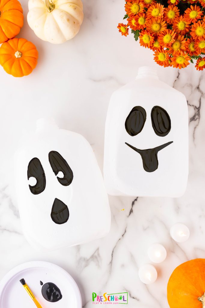 Next, give your ghosts a personality by drawing faces with black acrylic paint or a black Sharpie. Just a quick tip: be cautious with the Sharpie, as it can leave stains on clothes—so it’s best to wear play clothes while crafting!
