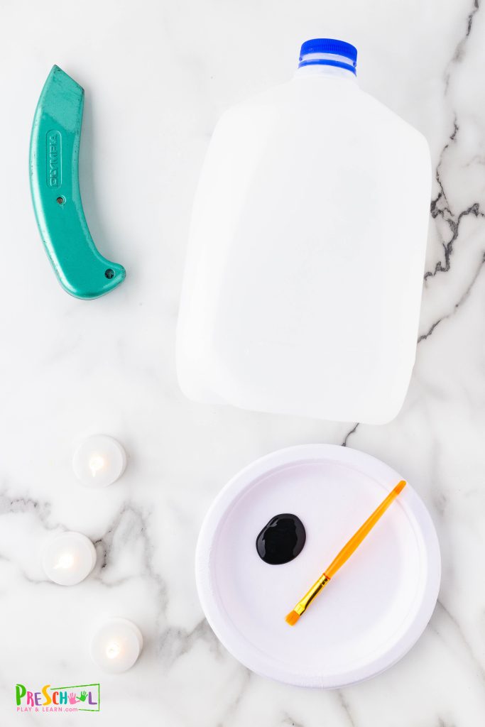 So gather your crafting supplies and make this a fun family activity!

empty milk jugs (one per ghost)
black acrylic paint or black sharpies
box cutter (for adult use)
tea lights (battery operated are the safest)