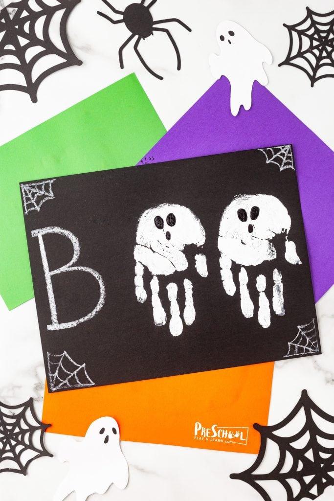 Ready to craft a fun BOO card? Start by making two handprints side by side on a piece of black cardstock. It's a simple yet creative way to add a personal touch to your Halloween greetings!
